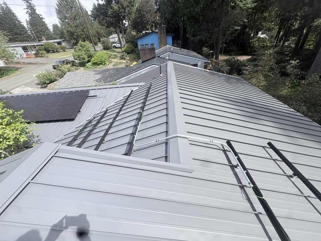 Roof angle showing Nu-Ray standing seam panels and black solar racking on a Shoreline home