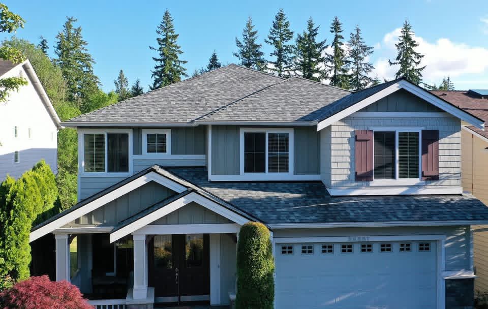 Front exterior of completed two-story Sammamish, WA home with CertainTeed NorthGate ClimateFlex shingles in Granite Gray, white fascia, and manicured landscaping