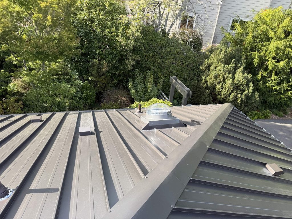 Exterior view of a VELUX Sun Tunnel rooftop dome installed on a Nu-Ray Series 2000 standing seam metal roof in West Seattle, WA