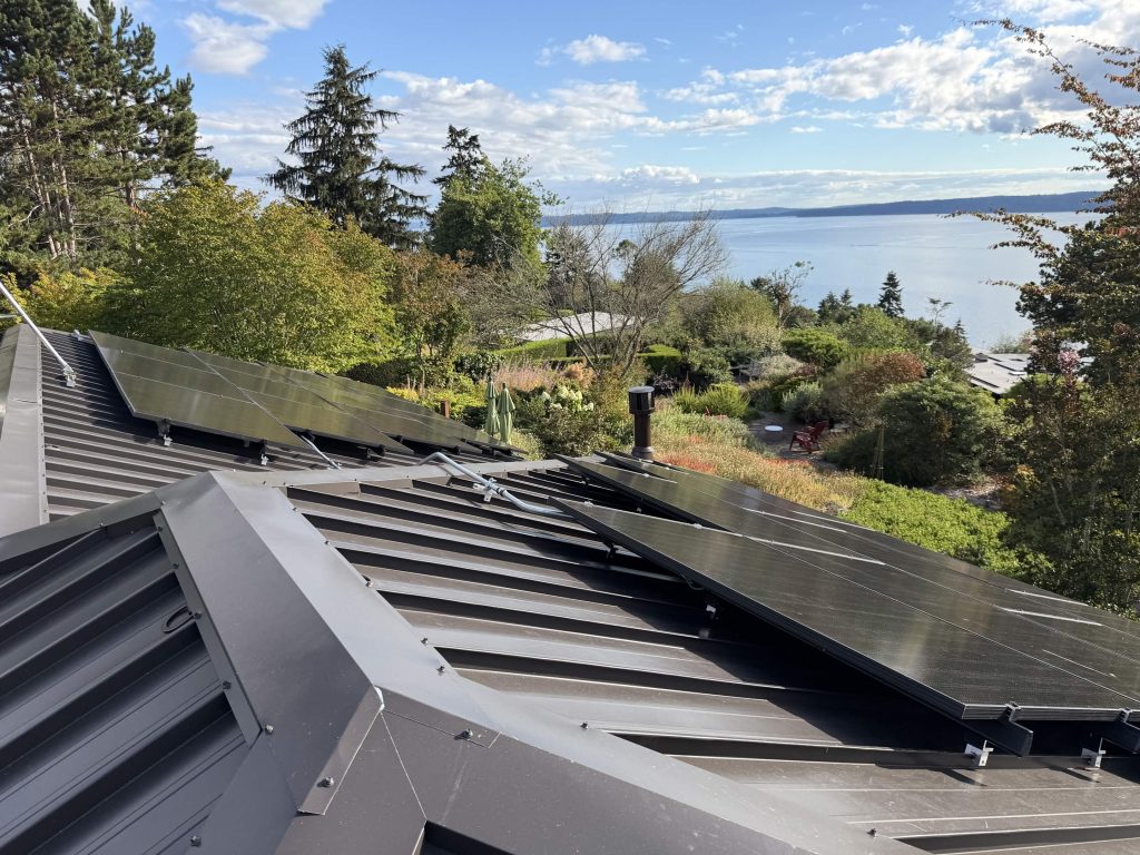 Dark bronze standing seam metal roof with CertainTeed Solstice solar panels and water views in West Seattle, WA