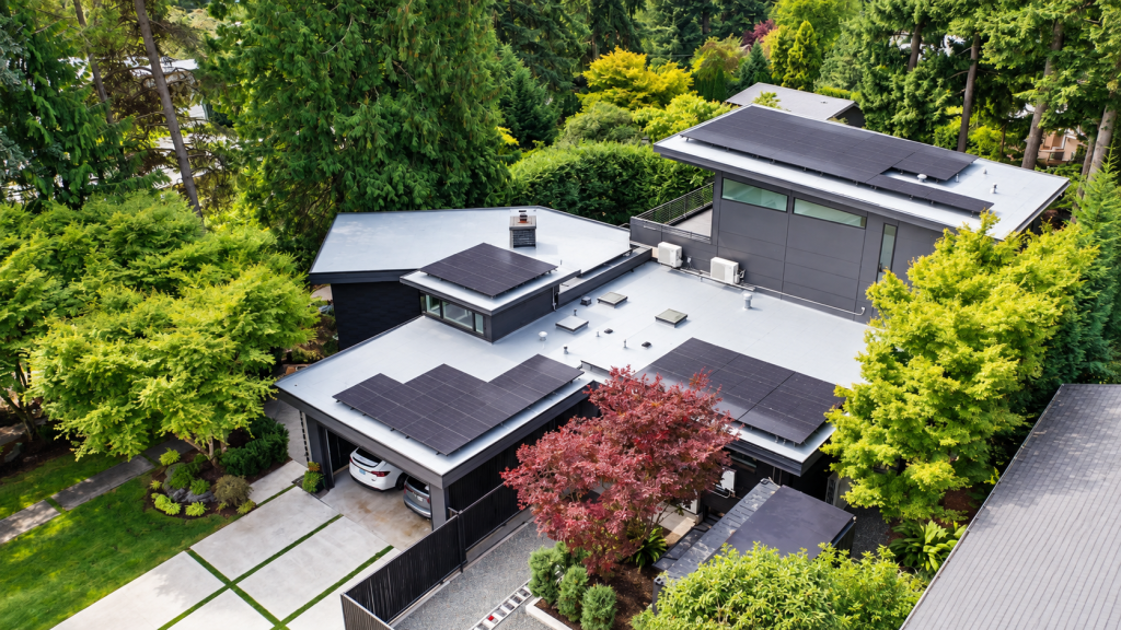 Overhead aerial of gray PVC membrane roof with Tesla solar panels on Bellevue residence
