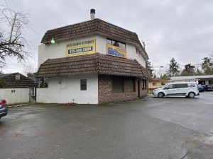 The small commercial building in Lake Forest Park, WA before the mansard roof replacement, showing the aging concrete tile roofing.